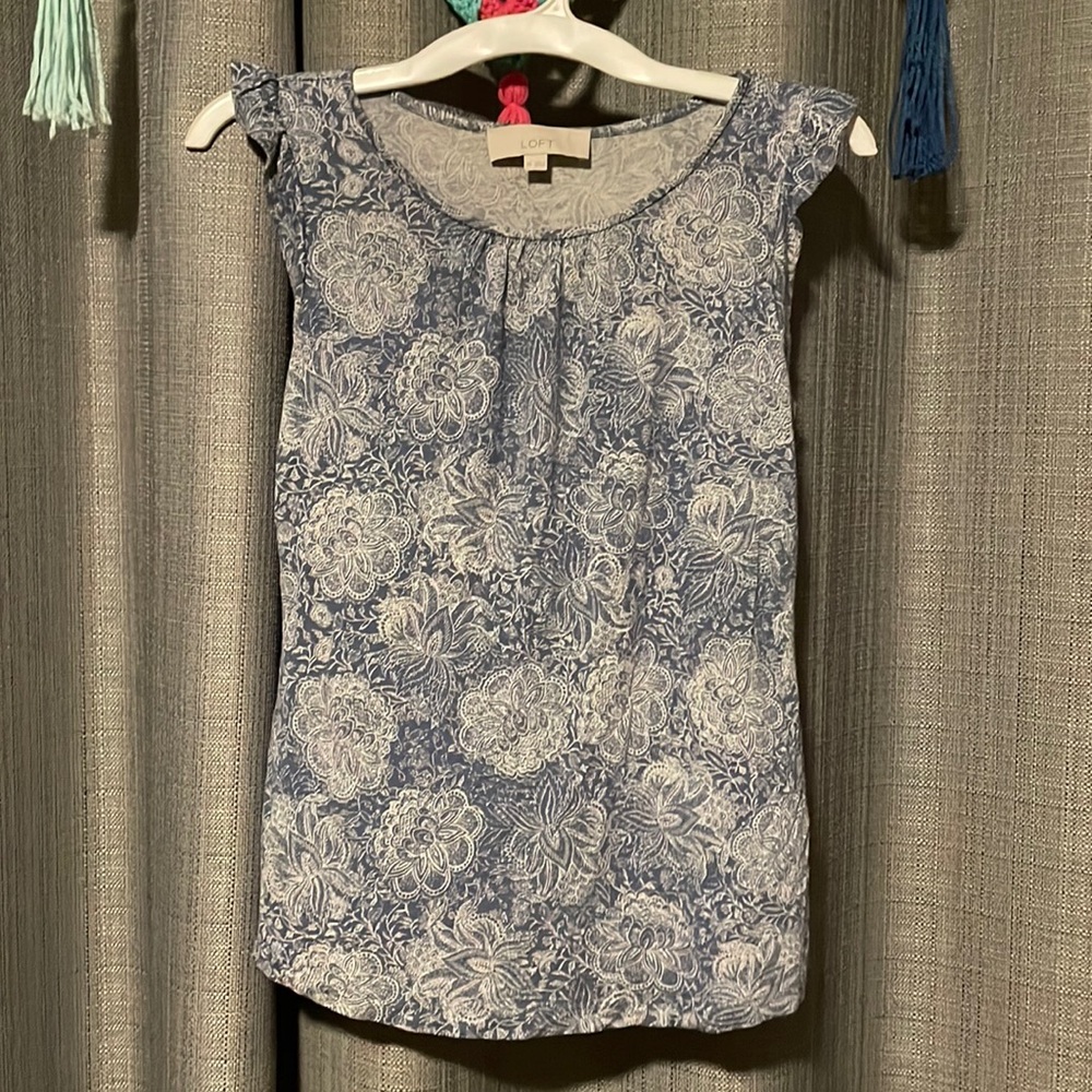 blue and white tank top with ruffles on shoulder.
